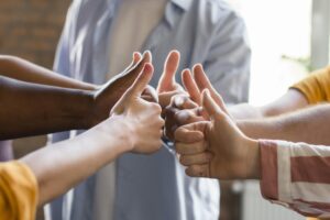 Diverse group of people giving thumbs-up, symbolizing a frictionless and positive keynote speaker experience for
