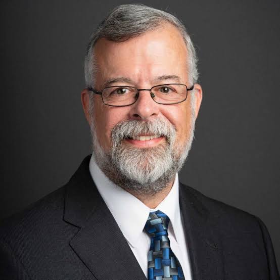 Professional portrait of keynote speaker and economist Alan Beaulieu wearing glasses.