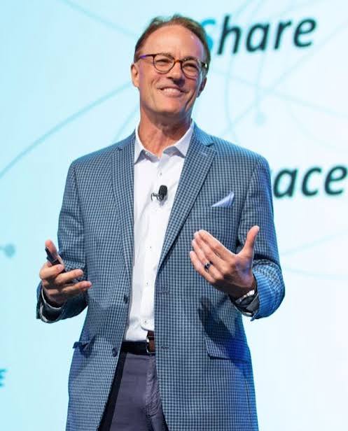 Keynote speaker Andrew Busch presenting on stage at a conference.
