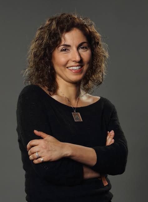 Portrait of keynote speaker and tech entrepreneur Anousheh Ansari with arms crossed.