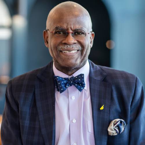 Dr. Yele Aluko, interventional cardiologist and healthcare keynote speaker, wearing a suit and bow tie.