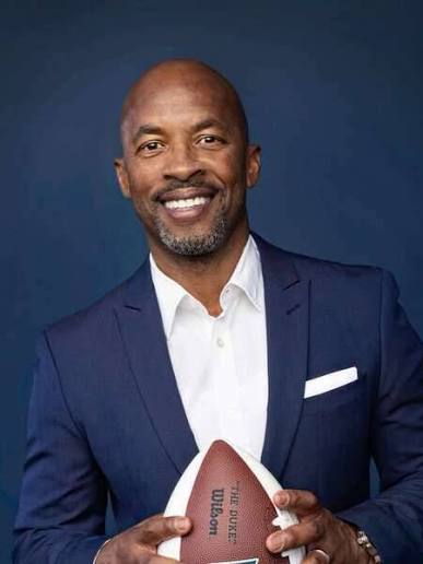 Former NFL wide receiver and keynote speaker JJ Birden holding a football.