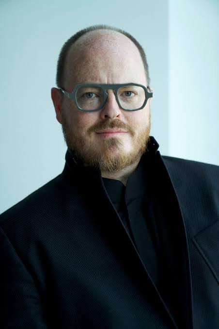 Portrait of keynote speaker and futurist Jonathan Brill wearing distinctive glasses.