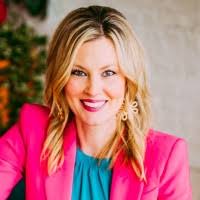 Kelli Thompson, award-winning executive coach and keynote speaker, in a pink blazer.