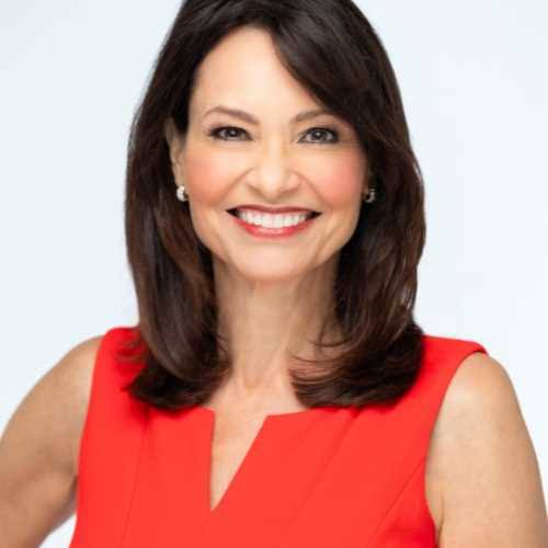 Emmy Award-winning keynote speaker and communications coach Liz Brunner wearing a red dress.