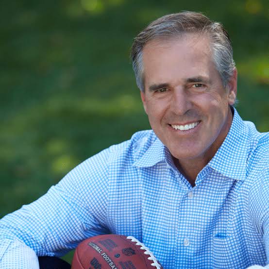 Former NFL player and healthcare keynote speaker Rolf Benirschke holding a football.