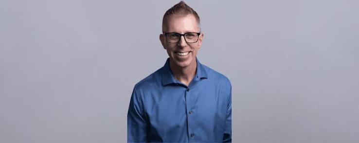 Professional keynote speaker Shawn Casemore smiling in a blue button-down shirt.