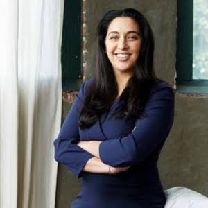 Global keynote speaker and innovation expert Simone Ahuja smiling with arms crossed.