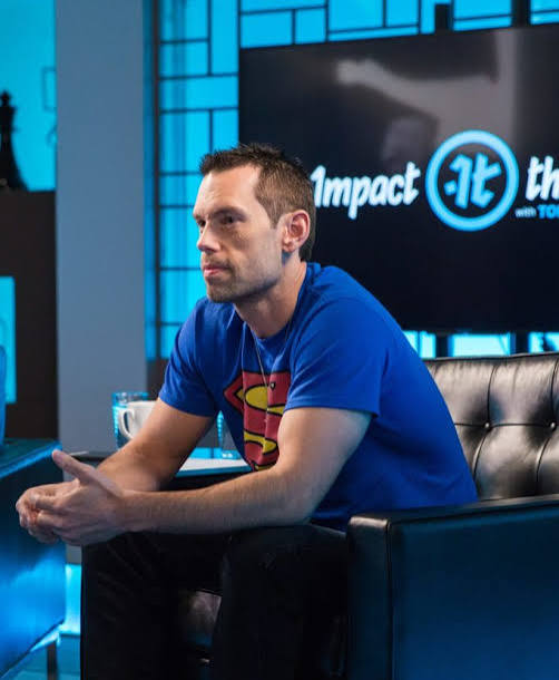 Entrepreneur and motivational speaker Tom Bilyeu sitting on set for Impact Theory.