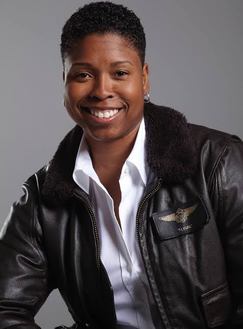 Keynote speaker and combat pilot Vernice FlyGirl Armour wearing a flight jacket.