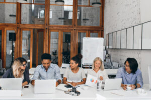 Diverse corporate team collaborating around a table in a modern office.